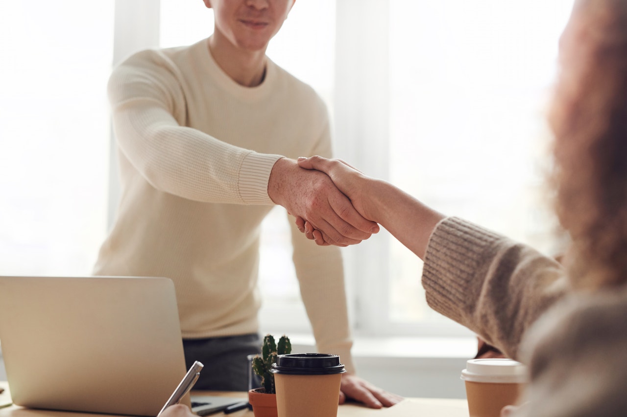 Business handshake and laptop illustrating starting a new business